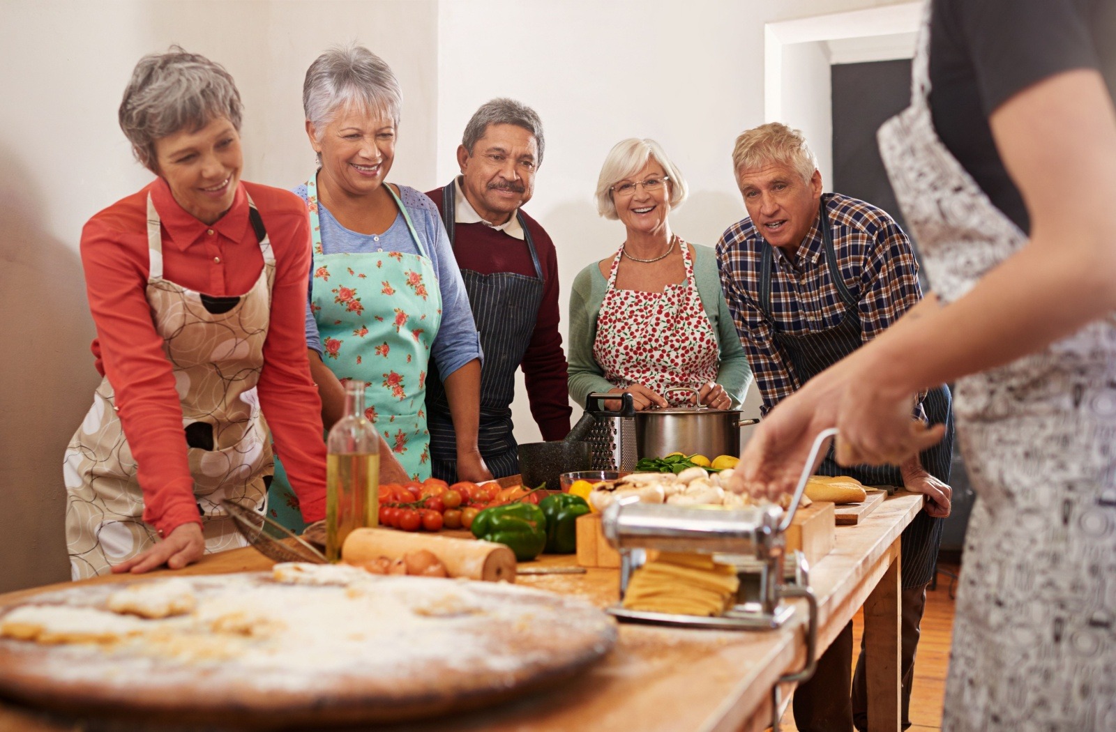 A group of retirees in independent living enjoy a cooking class together.
