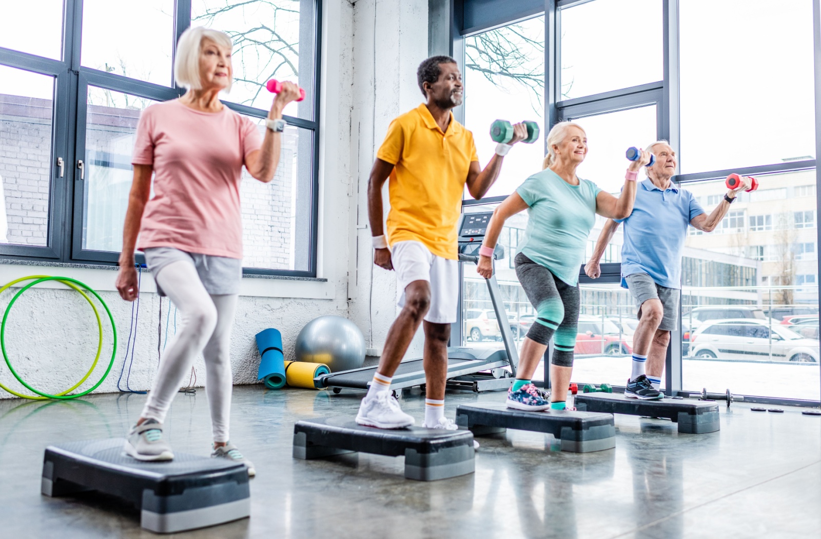 A group of active older adults attend a HIIT class at a senior living community.